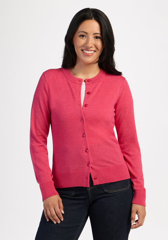 Woman with long dark hair smiles in the Woolx Caitlin Sweater - Vivid Rose and dark jeans against a plain background. | Sarah is 5'8", wearing a size S