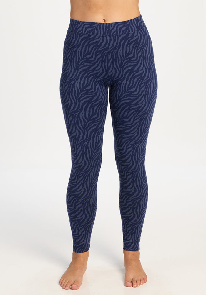 Person in Woolx Taylor Baselayer Leggings - Midnight Safari, standing barefoot against a white background. 