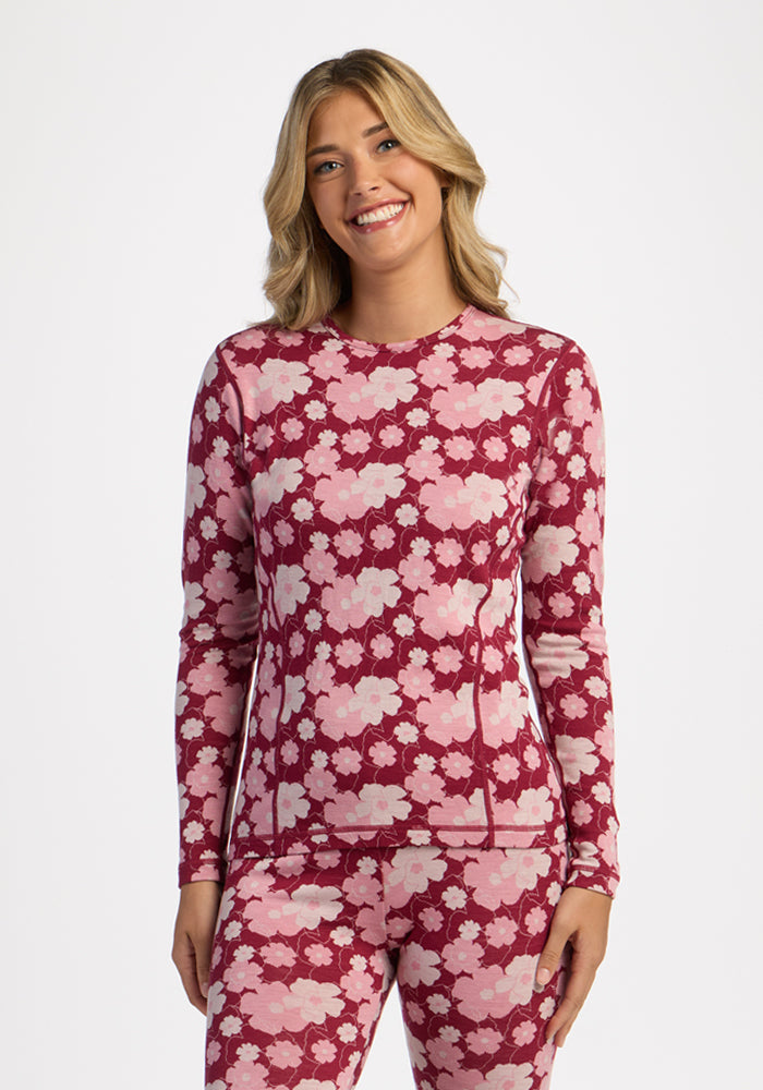 Smiling woman in Woolx Maddie Baselayer Top - Floral Crush, standing against a white background.