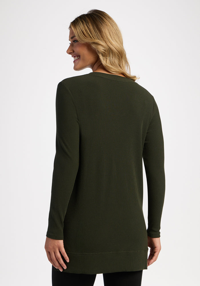 Woman with wavy blonde hair smiles in the Woolx Evie Ribbed Tunic - Duffel Bag, a cozy long-sleeve women’s top.
