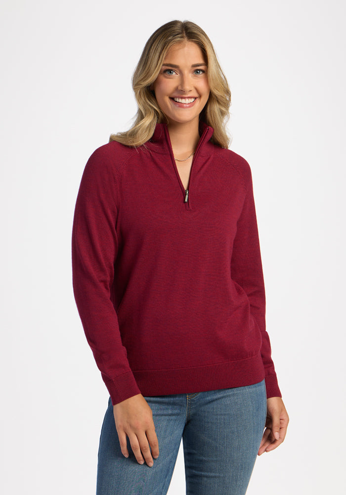 Woman with blonde hair in Woolx Collins Half Zip Sweater - Beet Red and blue jeans, smiling against a white background. | Ariana is 5'11", wearing a size S