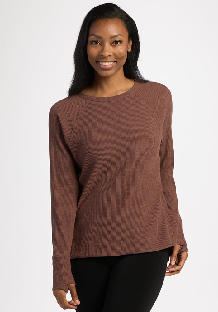Woman with long hair wears the Woolx Ainsley Sweater in Sable Heather and smiles at the camera against a white background.