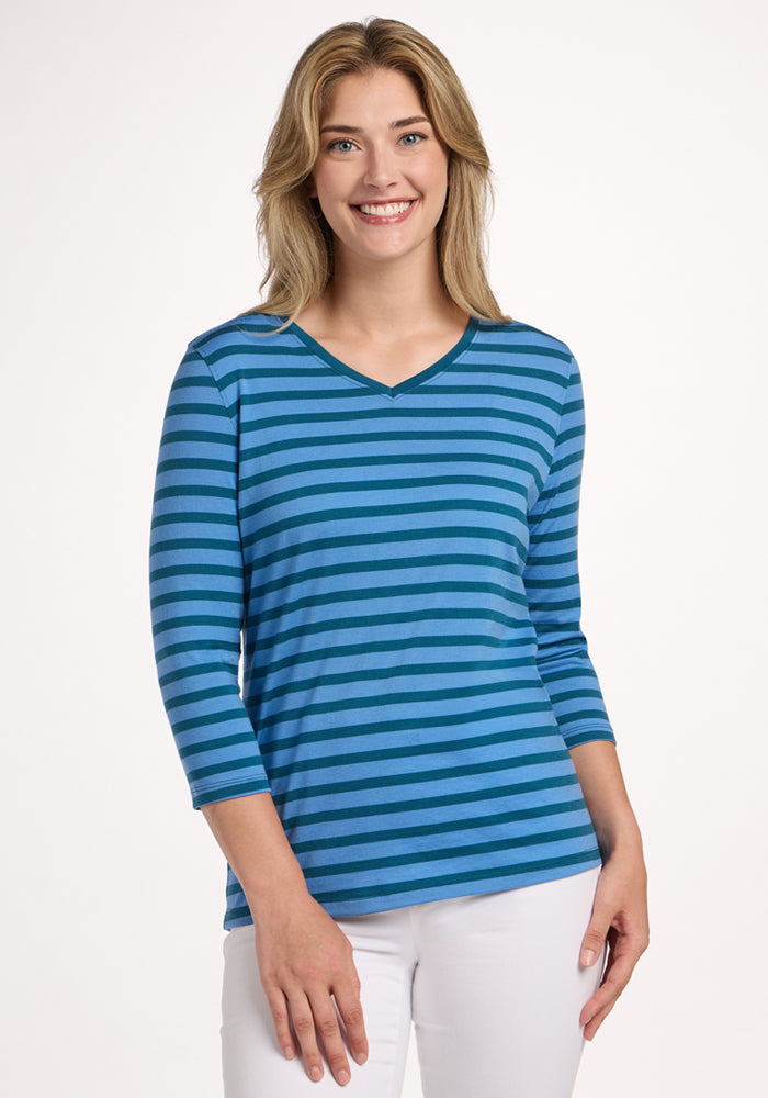 Woman smiling in the Woolx Elena 3/4 Sleeve V Neck - Coastal Stripe, paired with white pants. 