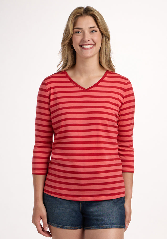 Woman smiling in the Woolx Elena 3/4 Sleeve V Neck - Wildberry Stripe, paired with denim shorts on a white background. 