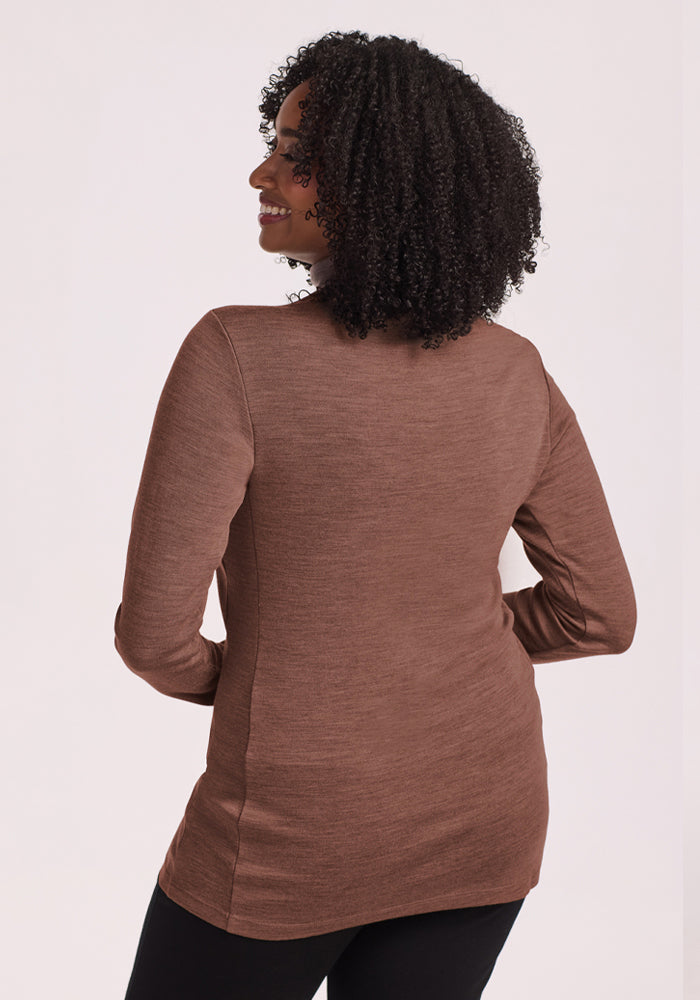 Curly-haired woman in the Woolx Peyton Turtleneck - Sable Heather, back view, against a light background.