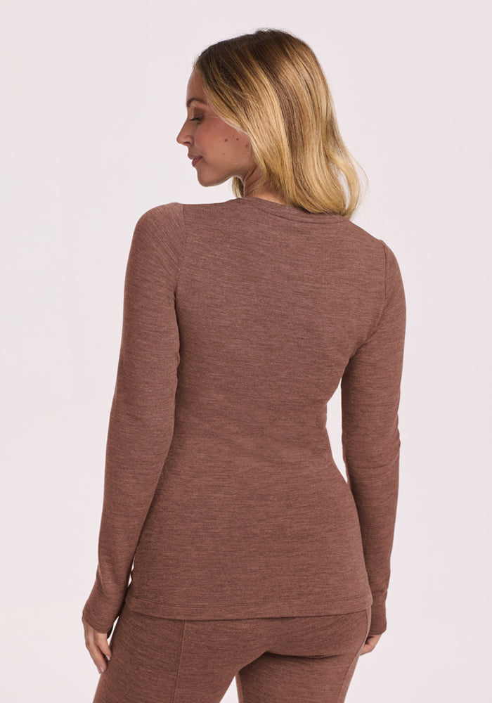Woman in the Woolx Sadie Baselayer Top - Sable Heather stands facing away, showing the back of her outfit.