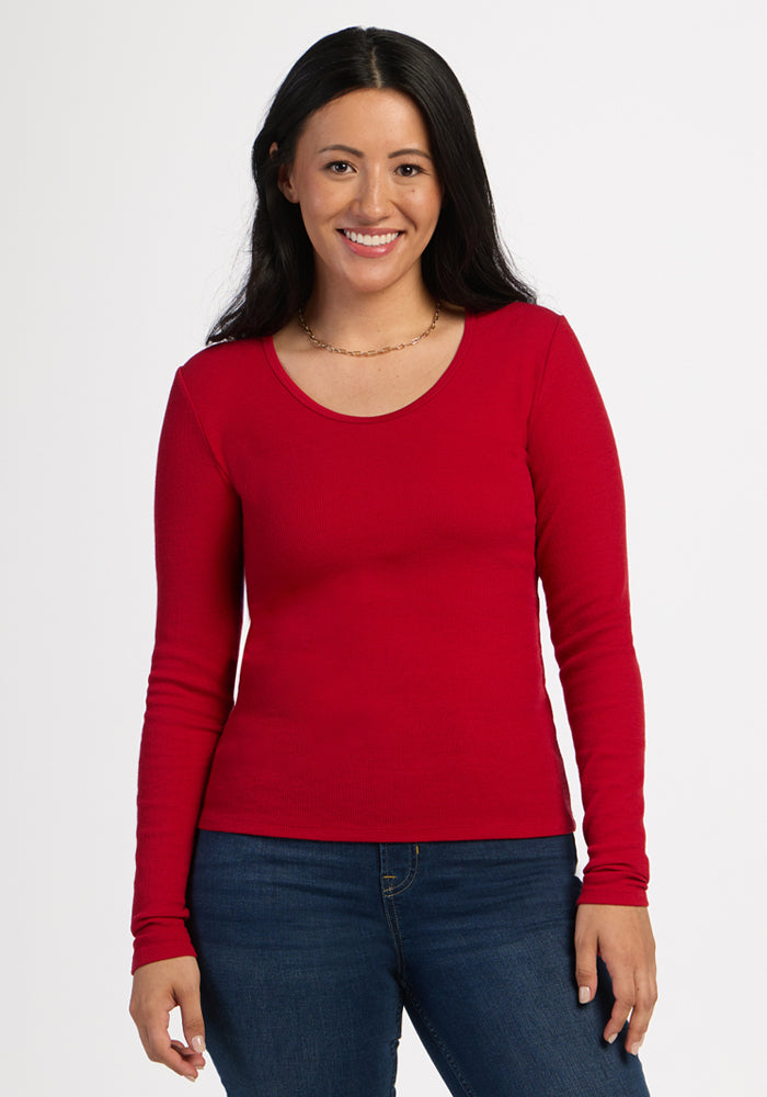 Woman in a Woolx Katie Ribbed Long Sleeve - Maraschino Cherry and jeans smiles against a white background. 
