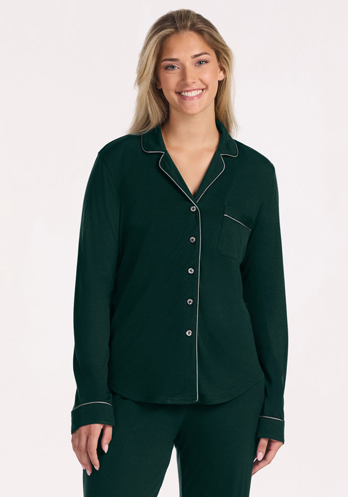 A woman wears a long-sleeved, dark green Harper FeatherTouch® Pajama Set top with light piping.