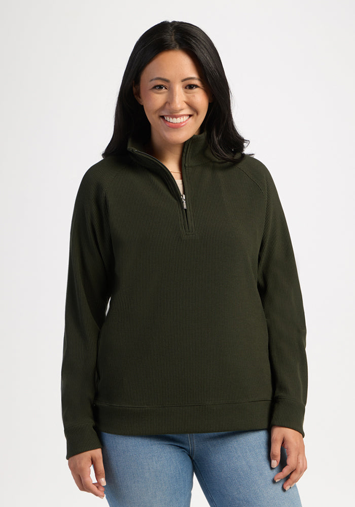 Woman wearing the Woolx Quinn Ribbed 1/4 Zip - Duffel Bag and jeans, smiling against a plain white background. 