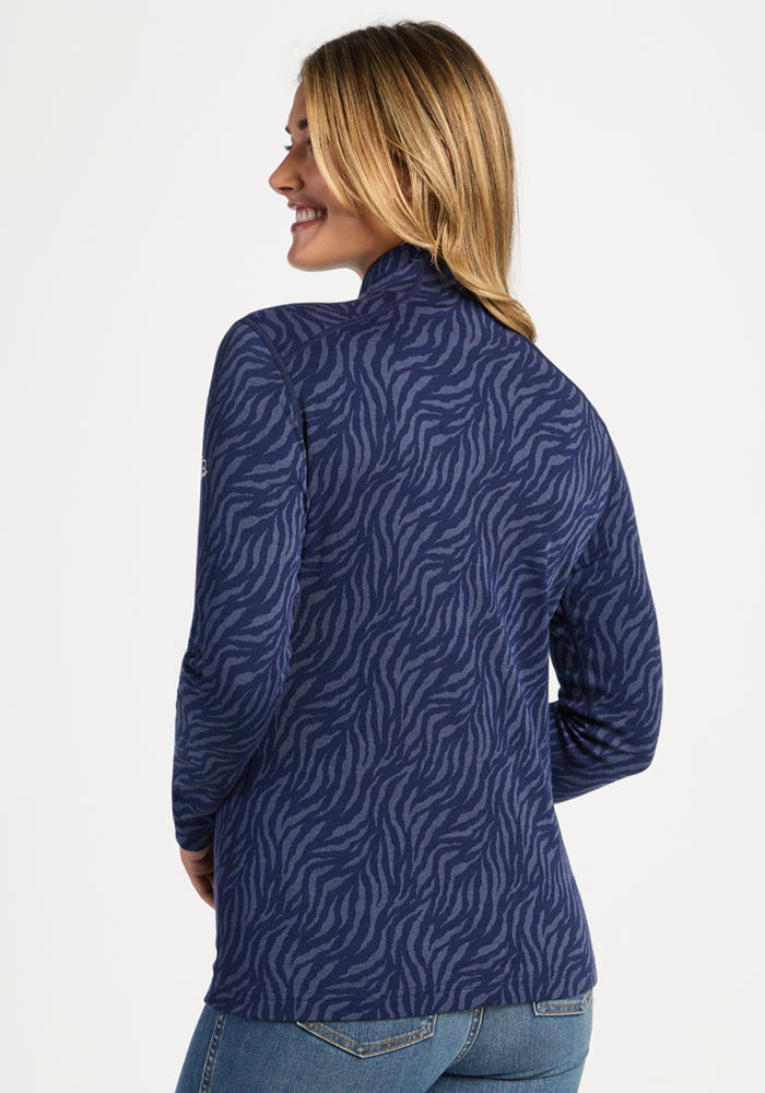 Woman smiling, wearing Woolx Emi 1/4 Zip - Midnight Safari, facing away, with light brown hair.