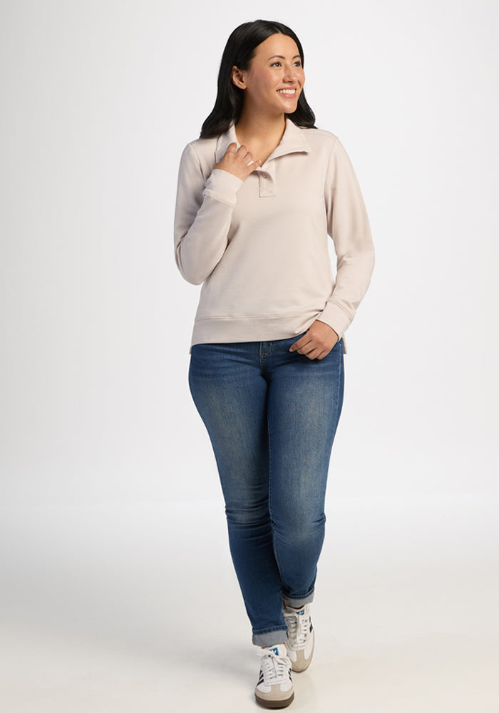 Woman in a Woolx Annie 3 Button Pullover - Ecru and blue jeans smiles against a plain white background.
