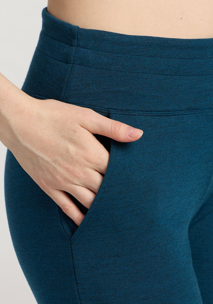 Close-up of a person wearing Woolx Madden Petite Joggers in Majolica Blue with their right hand in the pocket.