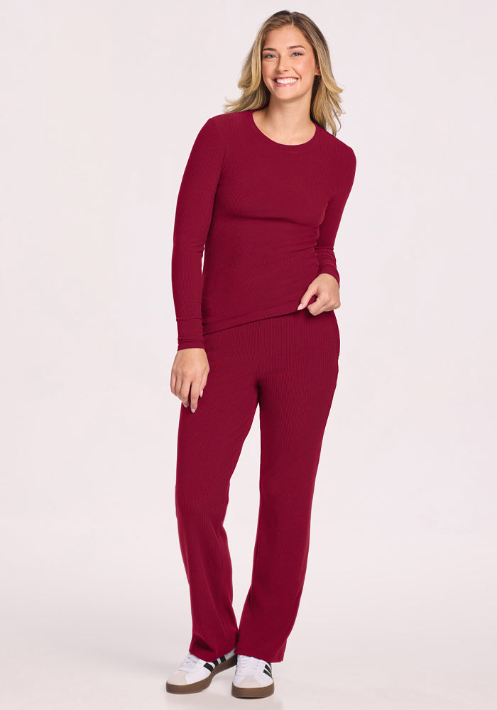 Smiling woman in Woolx Hadley Petite Crew - Beet Red, standing against a plain background.