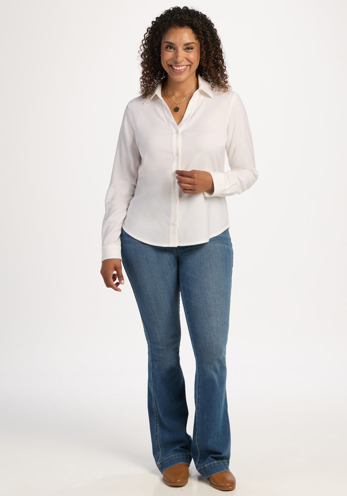 Woman smiles in a Woolx Lorelai Button Up - Eggshell, blue jeans, and brown shoes against a white background.
