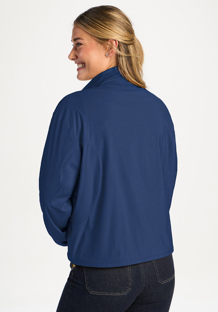 A person seen from behind wearing a dark blue Woolx Cooper Windbreaker - Vintage Indigo and dark jeans.