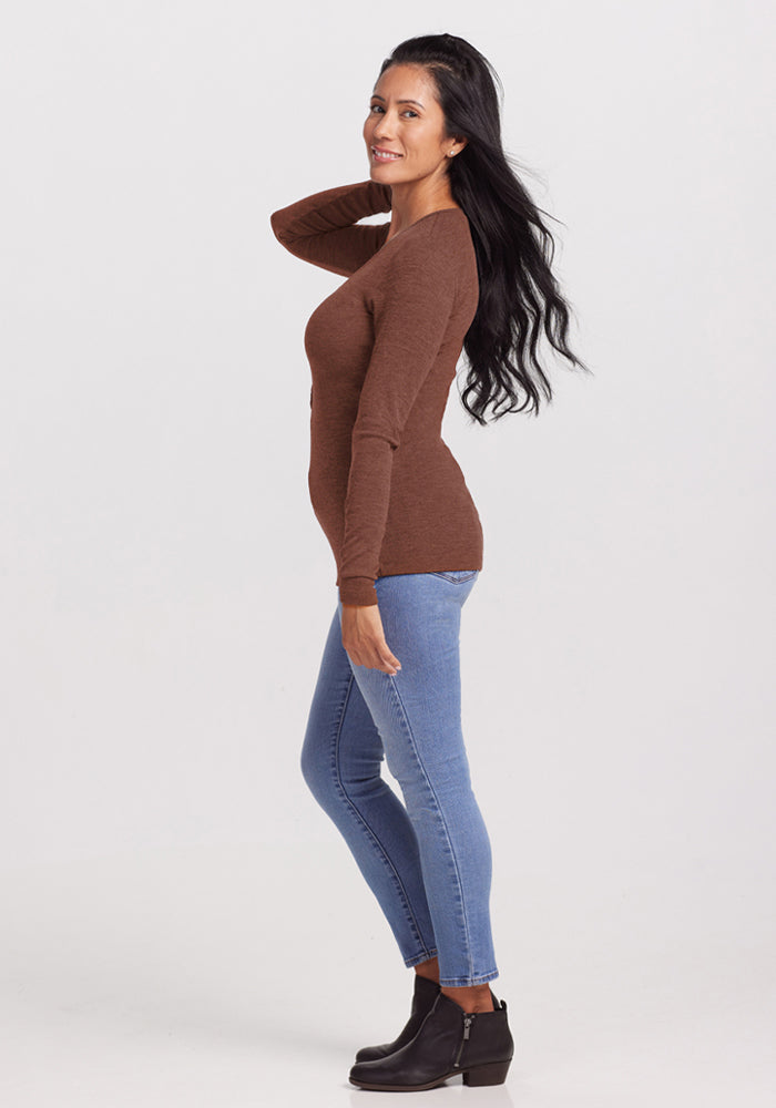 Woman in the Woolx Reese Ribbed Henley - Sable Heather stands sideways, smiling and touching her hair.