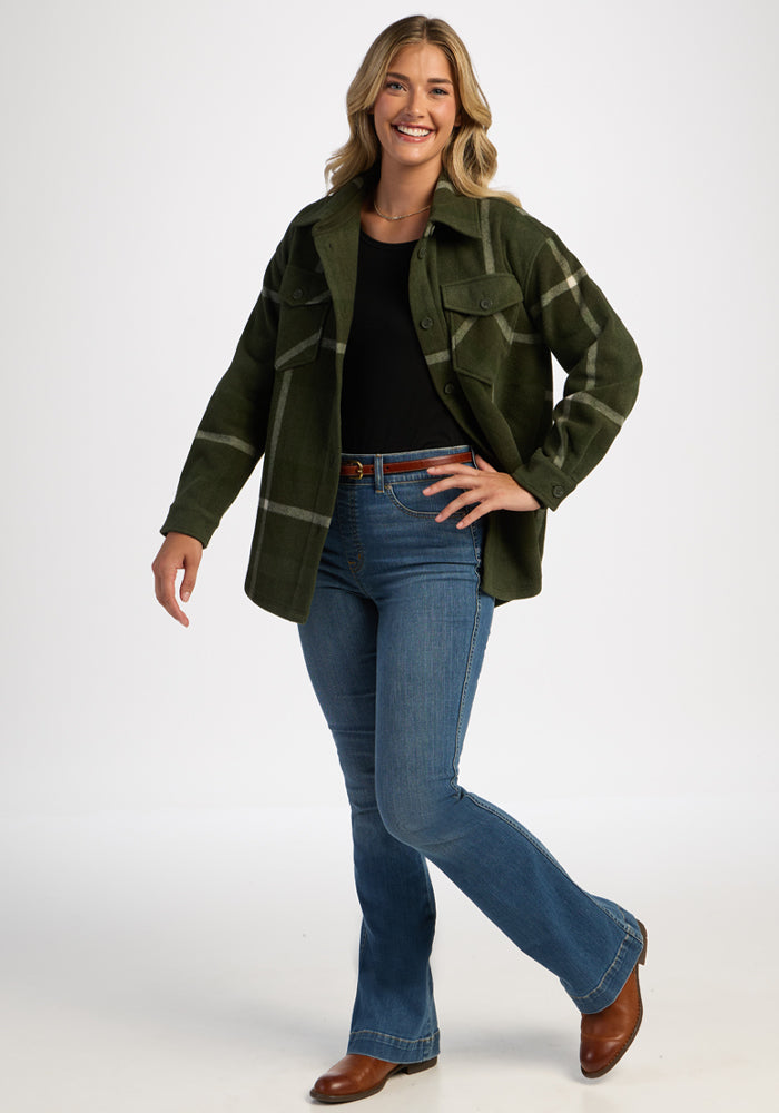 Woman in Woolx Sawyer Shacket - Driftwood Fern Plaid, black shirt, blue jeans, and brown boots on white background.