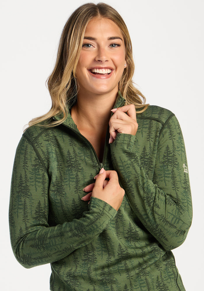 Smiling woman in a Woolx Emi 1/4 Zip - Forest Friends, holding the collar and looking at the camera.