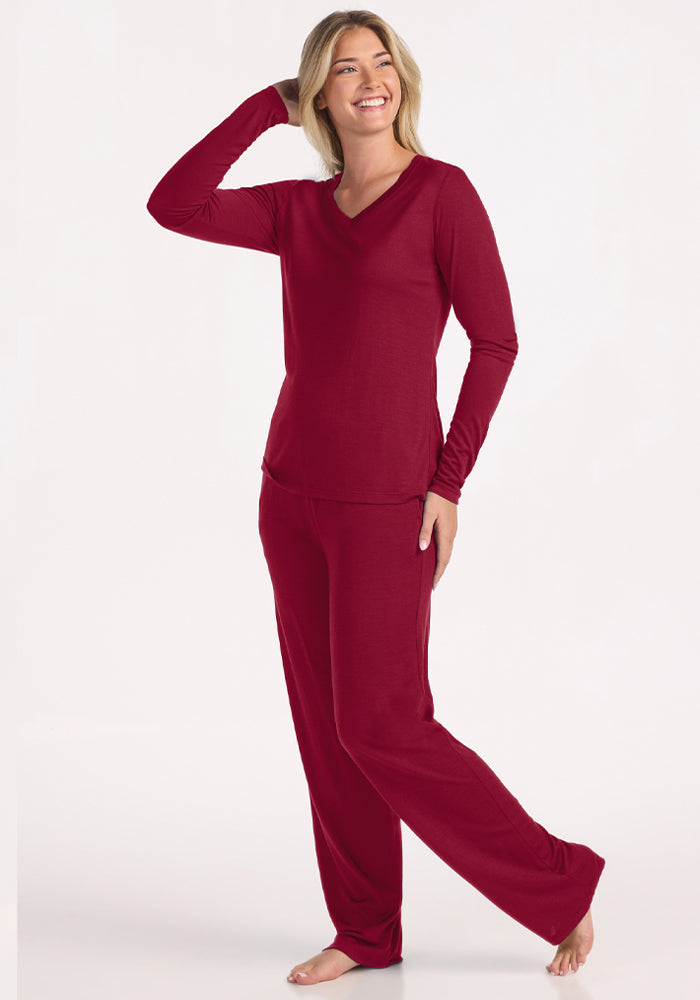 A woman smiles in a beet red Lily V Neck Lounge Top and matching lounge pants.
