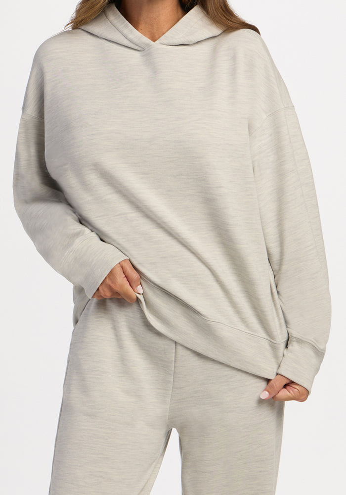 Person wearing a light ash Woolx Genevieve Hoodie and matching moisture-wicking lounge pants.