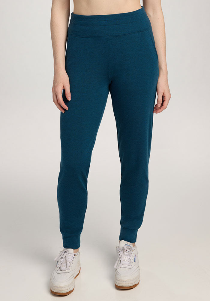 Model wears Woolx Madden Petite Joggers in Majolica Blue with white sneakers, against a light background.