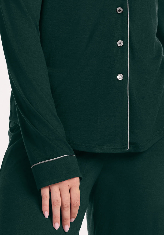 Woolx Harper FeatherTouch® Pajama Set in deep pine: a dark green long-sleeved Merino wool top with light piping and pants.