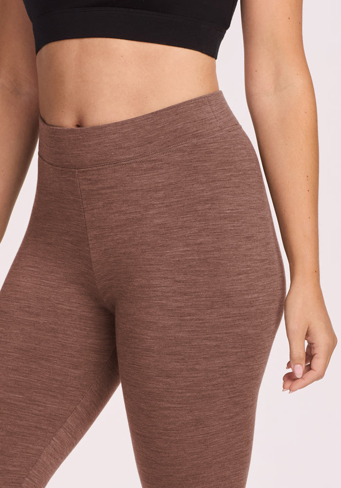 Woman wears Woolx Stella Leggings in Sable Heather with a black crop top, shown from shoulders to mid-thigh.