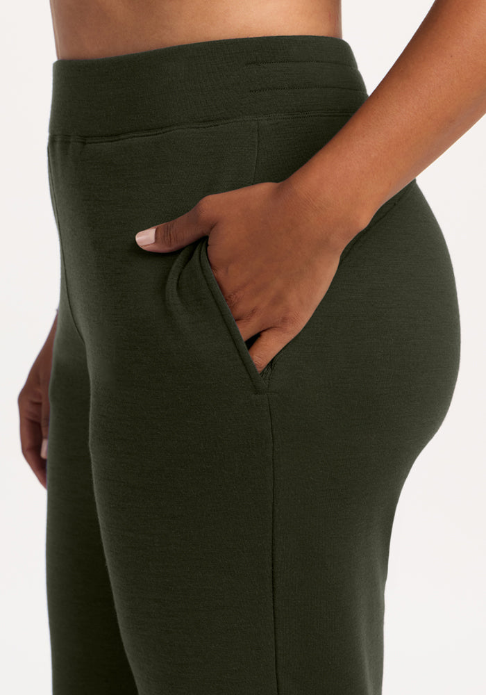 A hand rests in the pocket of Woolx Bree Lounge Pants - Duffel Bag, shown waist to thigh against a light backdrop.