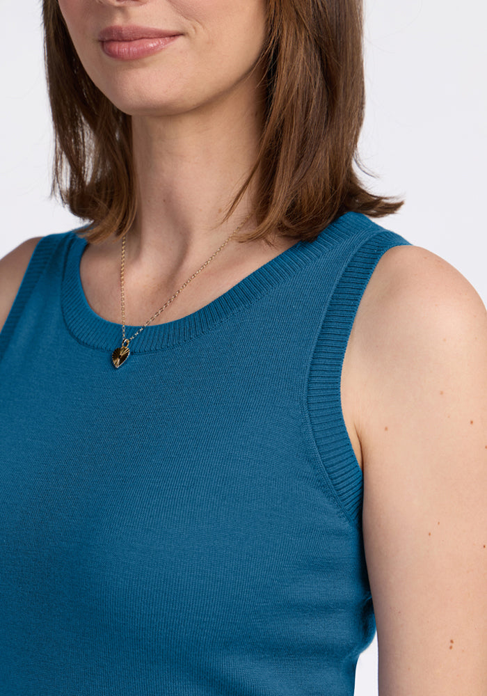 Woman in Woolx Chessy Tank Top - Blue Pine and gold necklace, shoulder to lips, on white background.