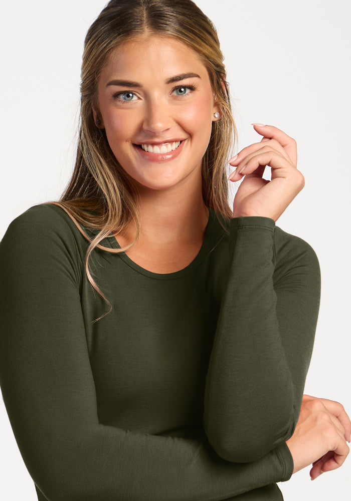 Smiling woman in Woolx Margot Bodysuit - Everleaf poses confidently against a plain white background.