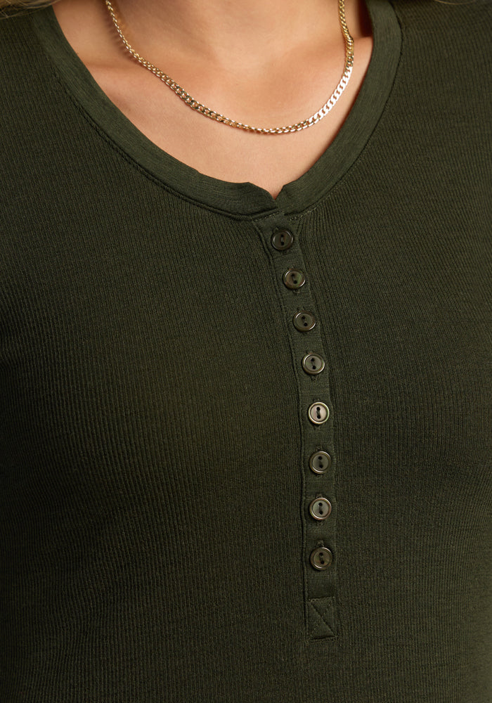 Close-up of a person wearing the Woolx Reese Ribbed Henley - Duffel Bag with a thin gold chain necklace.