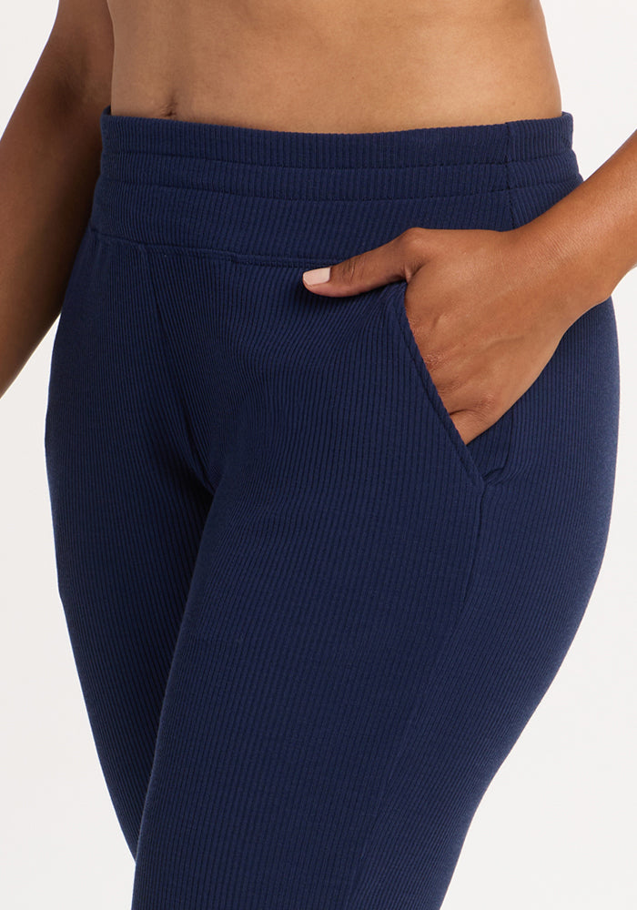 A person wears Woolx Lennon Ribbed Joggers in Ocean Cavern, hand in pocket, shown waist to mid-thigh.