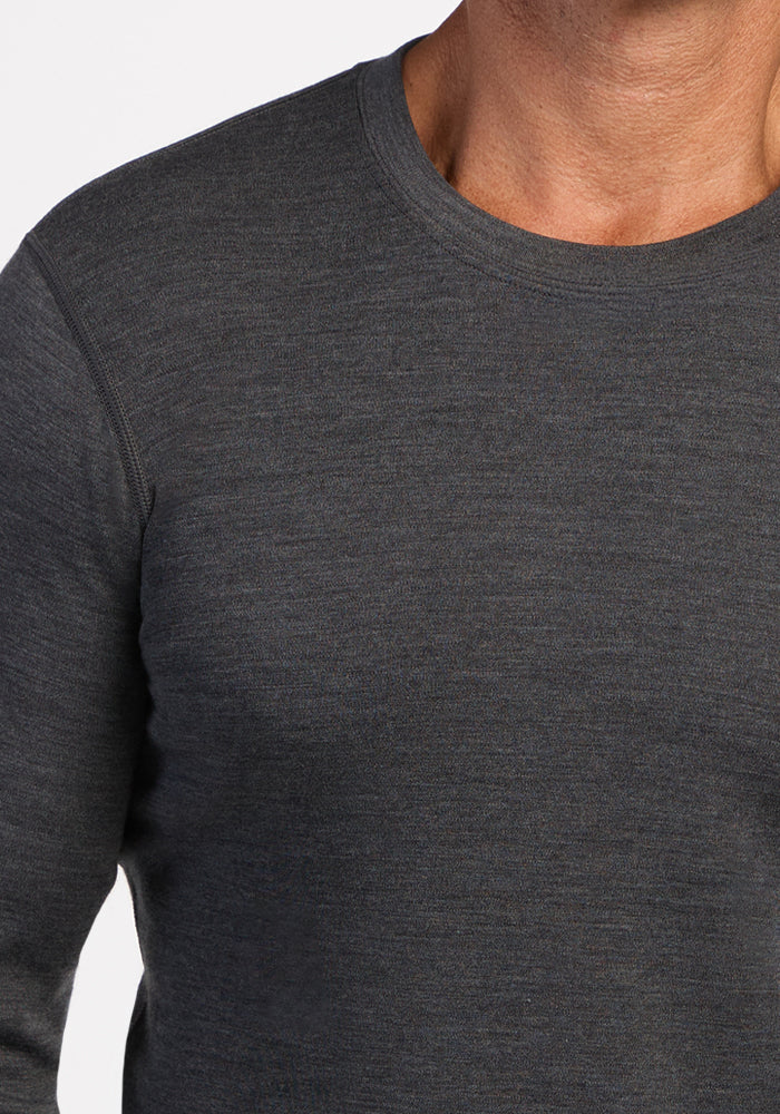 A person in a Woolx Explorer Base Layer - Cinder Melange, long-sleeve crew neck, shown shoulders to chest.