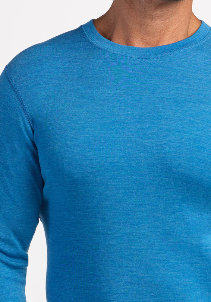 Someone wearing Woolx Explorer Base Layer - Blue Razz, shown shoulders to upper chest, on a white background.