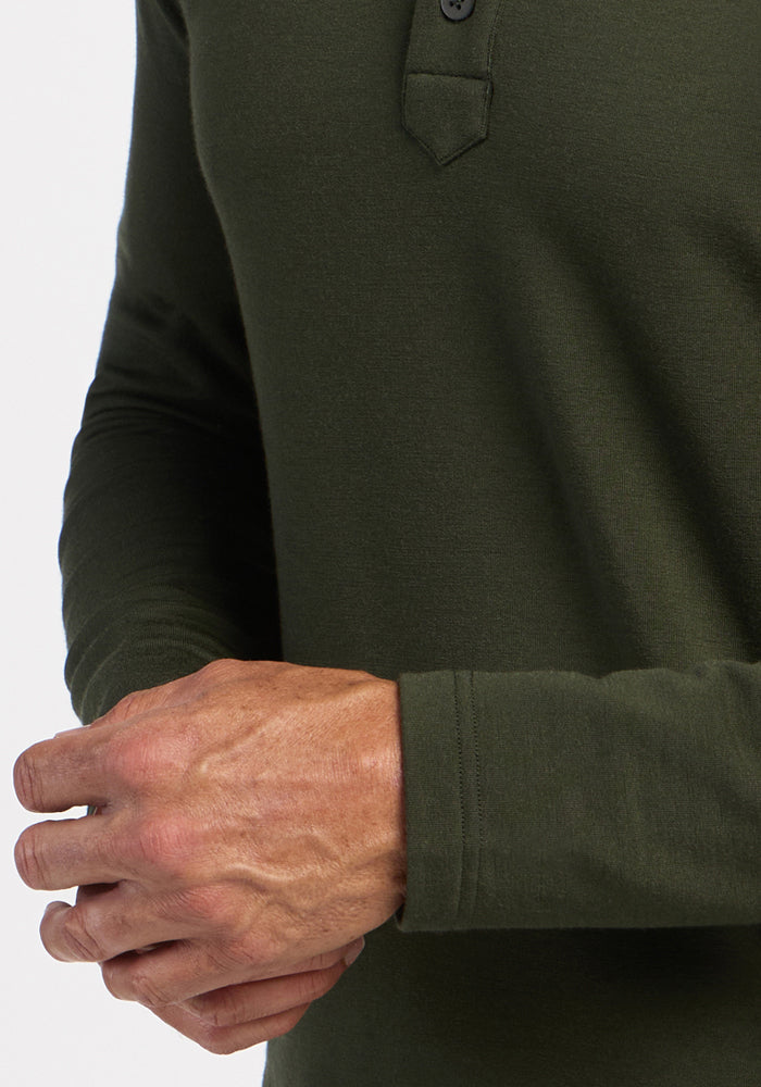 A person in a Woolx Jackson Henley - Duffel Bag adjusts their left cuff with their right hand.