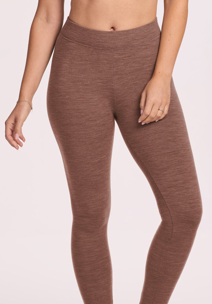 Model wearing Woolx Stella Petite - Sable Heather leggings, waist to feet, hand on thigh, light backdrop.