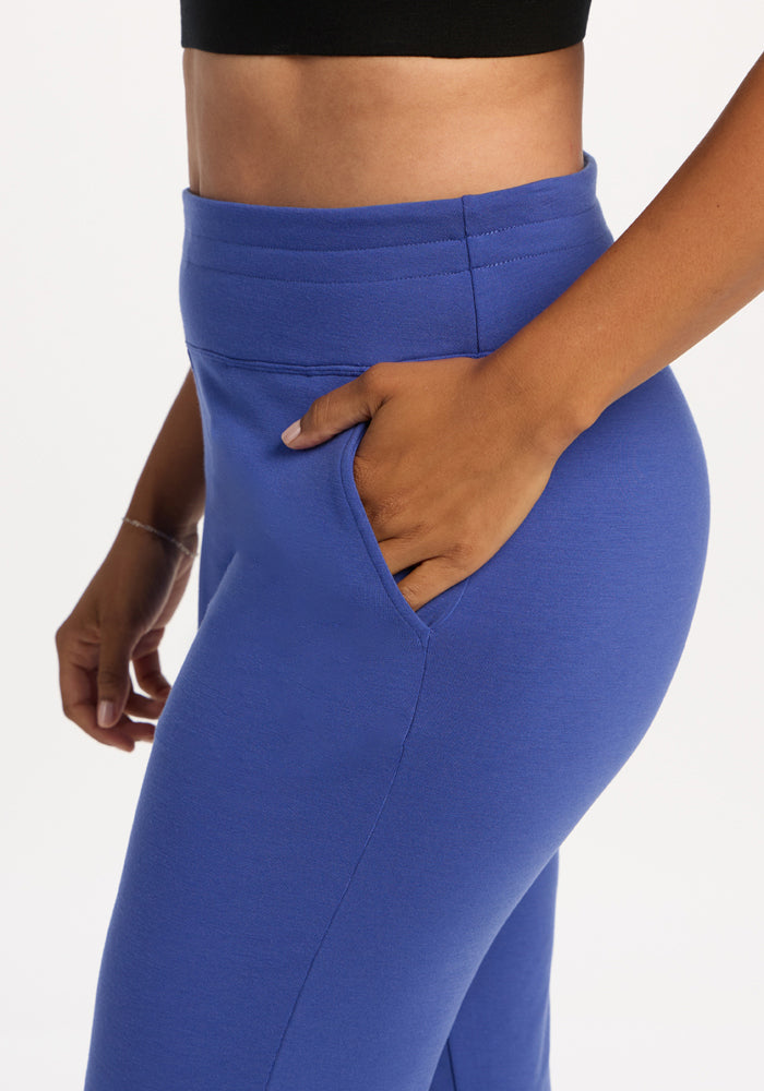 Model in Woolx Madden Petite Joggers - Royal Blue, hand in pocket, black crop top; shown waist down.