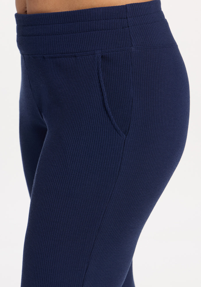 Close-up of a person wearing Woolx Lennon Ribbed Joggers in Ocean Cavern, with an elastic waistband and side pocket.