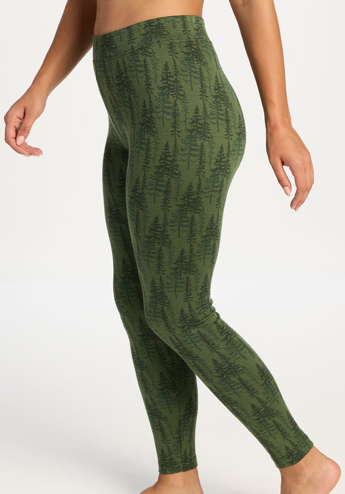 Model in Woolx Taylor Baselayer Leggings - Forest Friends stands barefoot before a plain backdrop.