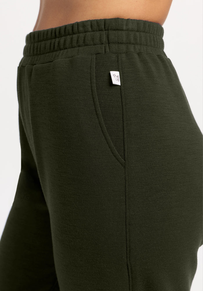Close-up of a person in Woolx Parker Sweatpants - Duffel Bag, featuring moisture-wicking fabric and an elastic waist.