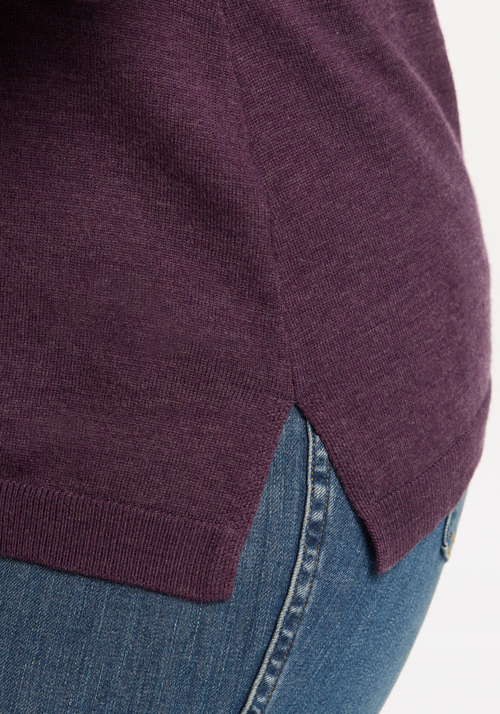 Close-up of a person in the Woolx Josie Cowl Neck Sweater - Purple Iris, perfectly paired with classic blue jeans.