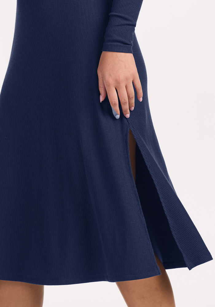 Someone models the Woolx Caroline Ribbed Twirl Dress - Ocean Cavern, hand resting casually near the side slit.