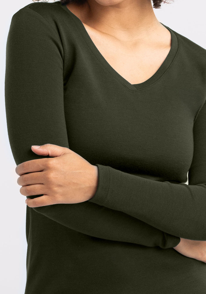Model wearing Woolx Eva Tunic in Duffel Bag green Merino wool, one arm crossed for cozy midweight warmth.