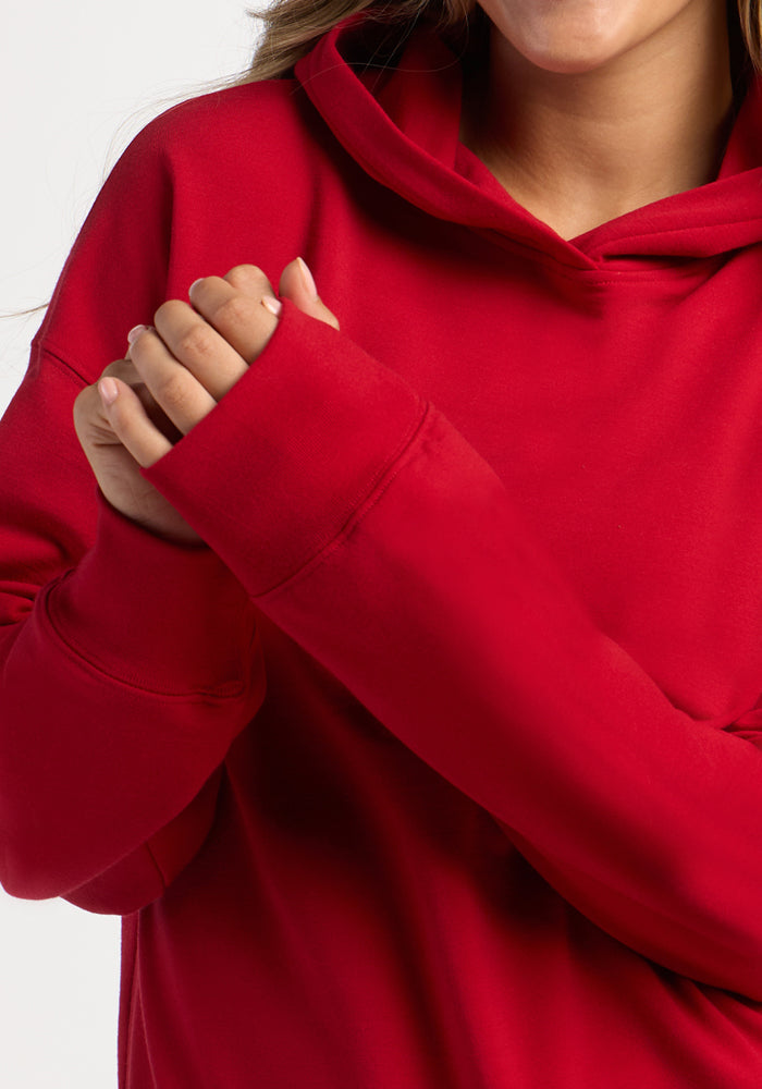 Close-up of a person wearing a moisture-wicking, bright red Genevieve Hoodie - Maraschino Cherry.