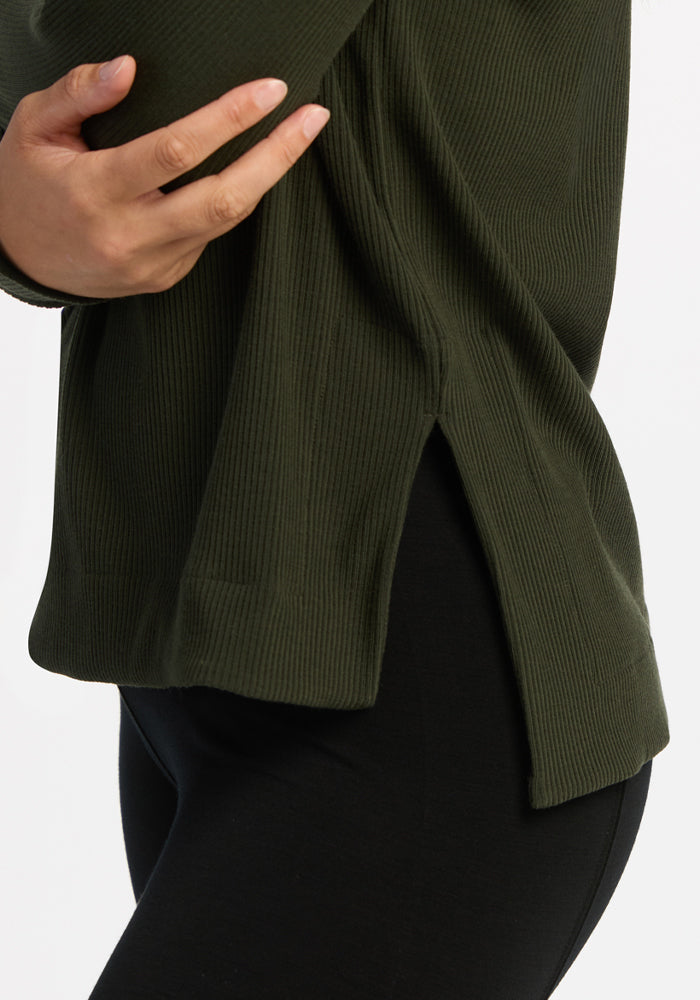 Woman in Woolx Ainsley Sweater - Duffel Bag with side slit, black pants, hand resting at her side.