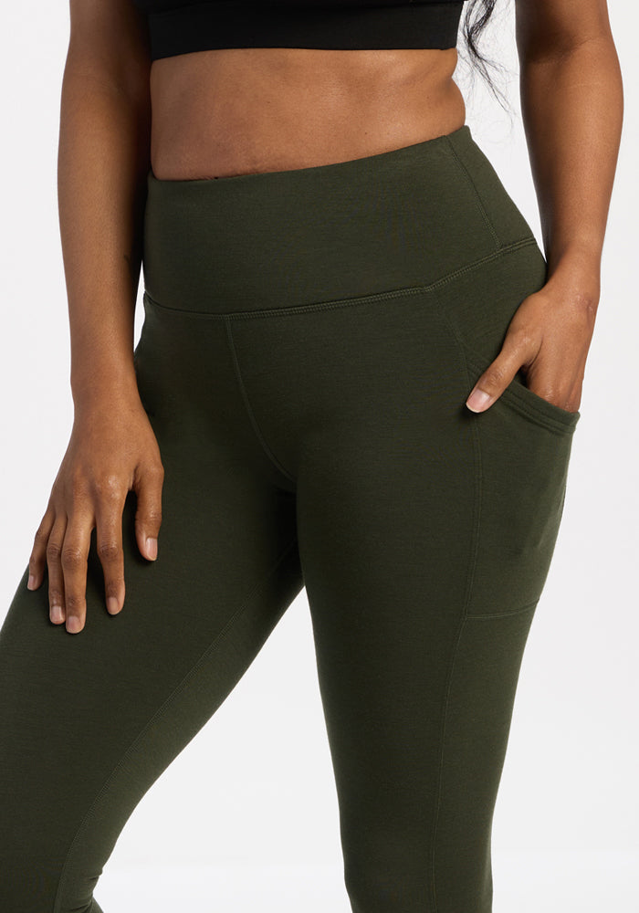 Woolx Piper Pocket Petite - Duffel Bag in olive green, styled with a black crop top and hand in the bag’s side pocket.