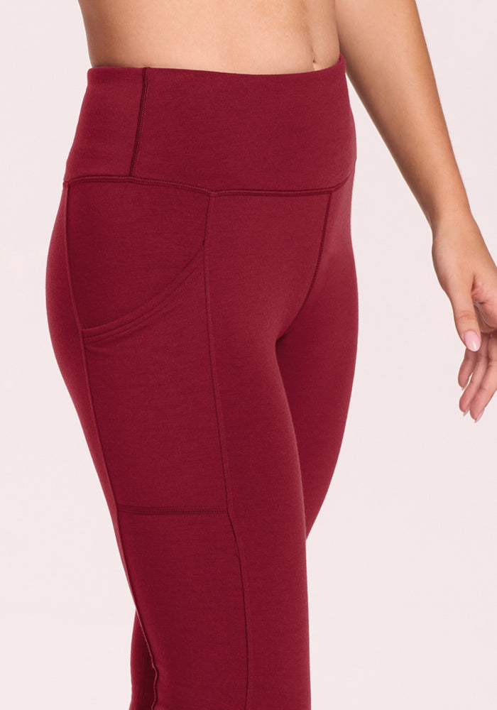 Model in Woolx Piper Pocket Leggings - Pinot Noir, high-waisted, moisture-wicking, pocketed, waist to mid-thigh.