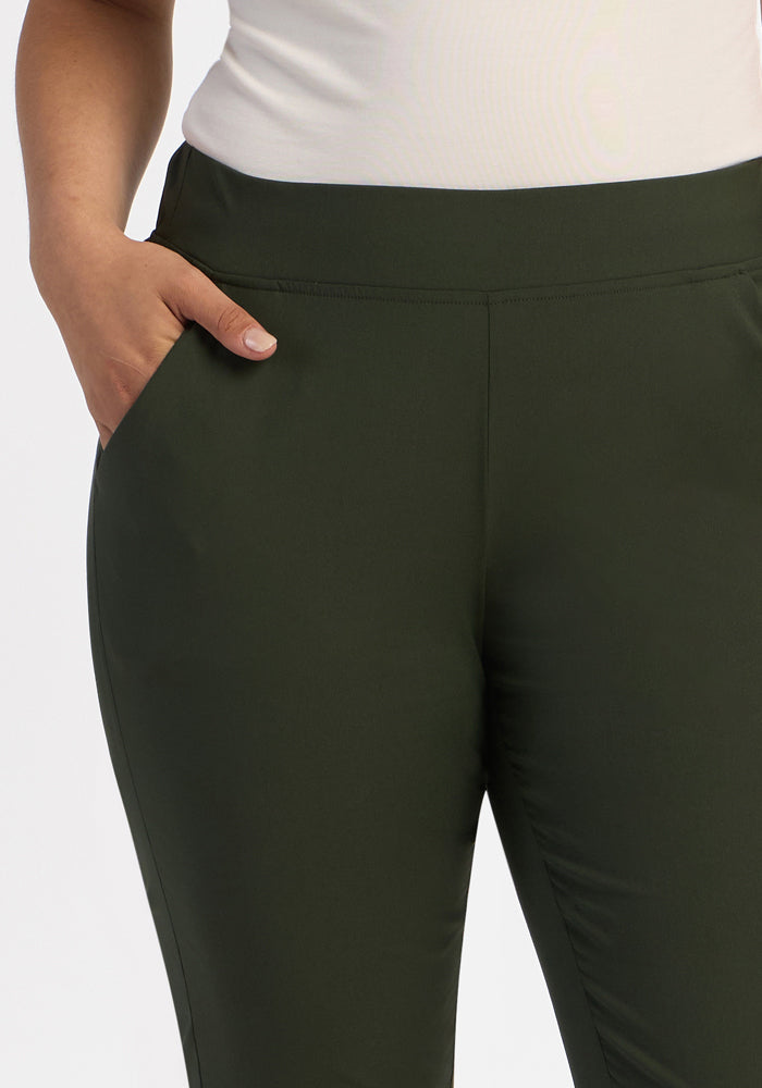 Wearing Woolx Nicole Ankle Pants in Duffel Bag and a white top, a person stands against a white background.
