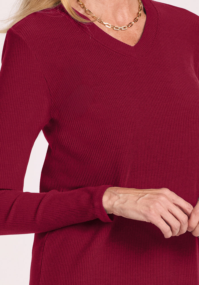 Person wearing Woolx Evie Petite Tunic in Beet Red and a gold chain necklace, hand gently raised.