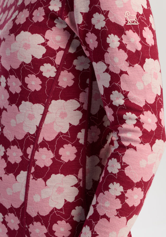 Close-up of Woolx Maddie Baselayer Top - Floral Crush, showing red/pink florals and white logo on shoulder.
